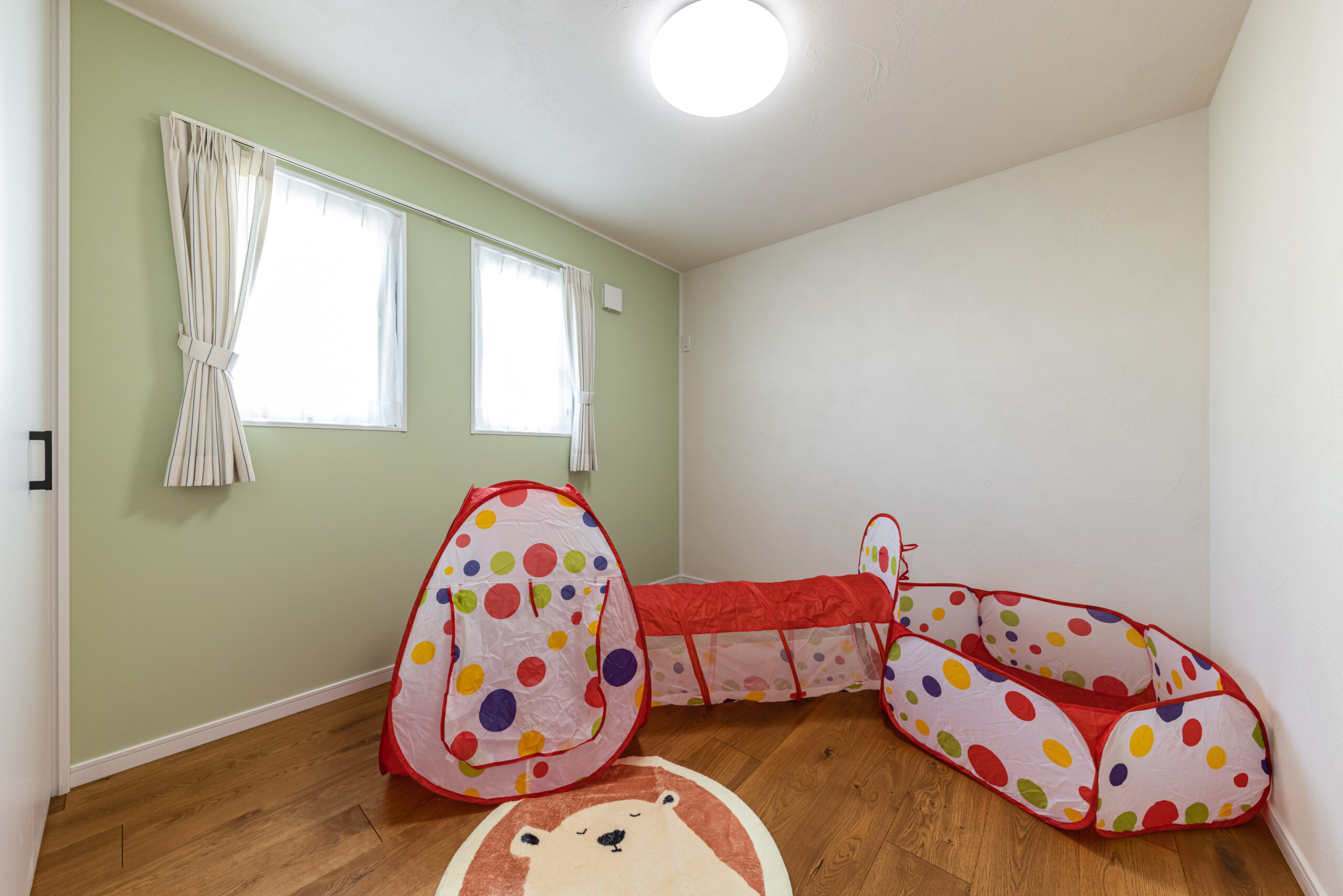 淡いグリーンのアクセントウォールが可愛い子ども部屋